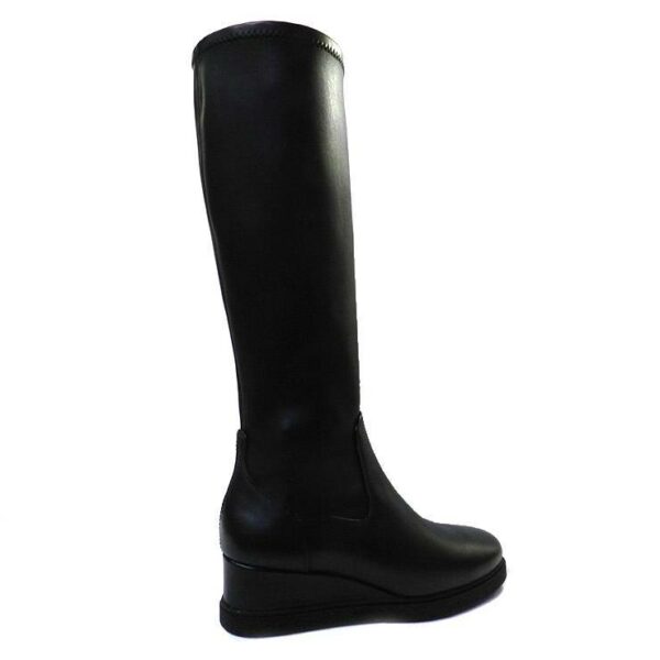 Bota de la marca Unisa, modelo Junyu en color negro. Bota alta de piel lisa y caña elástica. Suela de goma antideslizante de cuña negra de 5 cm de altura. 