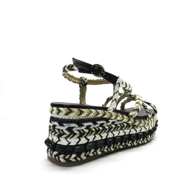 Sandalia de la marca Alma en Pena modelo Adularia en color negro. Sandalia con plataforma realizada en piel con detalle de tiras trenzadas de rafia, textil y tachuelas. Parte delantera con tiras trenzadas de rafia. Cierre con hebilla ajustable. Plantilla acolchada de piel. La altura del tacón es de 6cm.