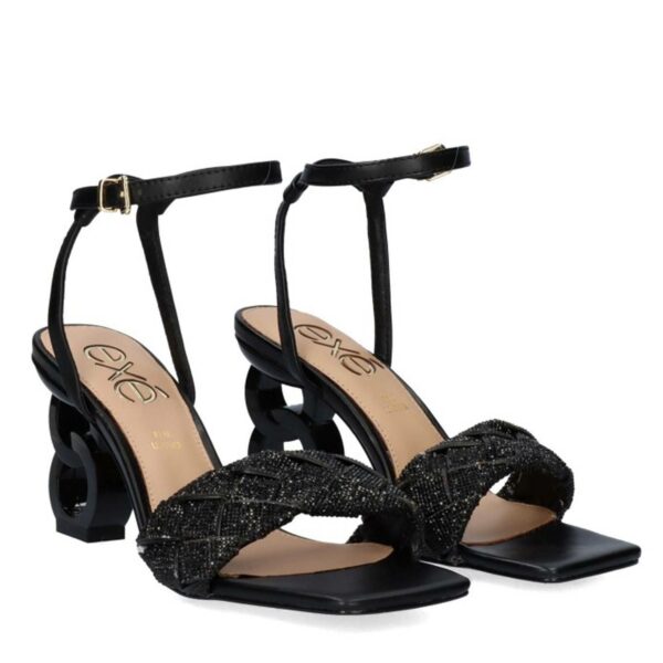 Sandalia de la marca Exe, modelo Lilian-180 en color negro. Sandalia de material sintético con tacón bajo y cierre con hebilla al tobillo.