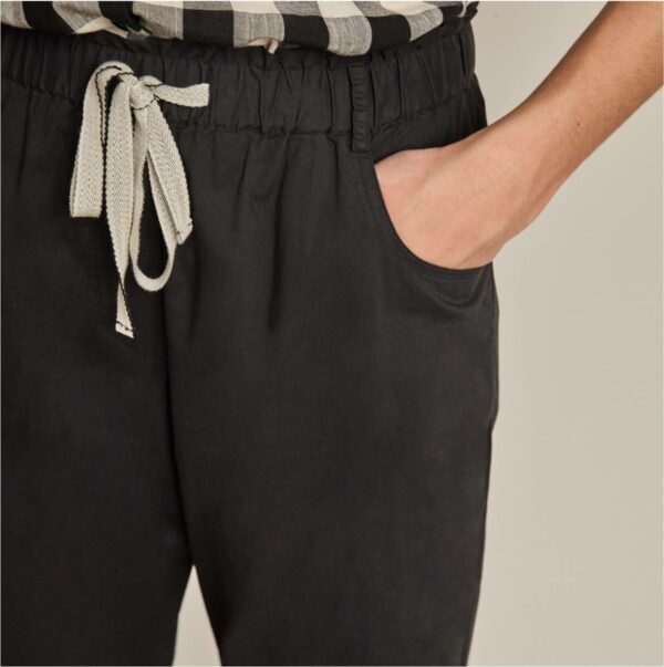 Pantalón de la marca Yerse, modelo 36858 en color negro. Pantalón paperbag largo en popelín. Cinturilla elástica con cinta decorativa a contraste y detalle de bolsillos laterales. 100% algodón