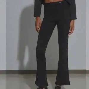 Pantalón de la marca BSB modelo 050-212020 en color negro. Pantalones acampanados elaborados en tejido elástico. Sin bolsillos. Cierre frontal con botón y cremallera.