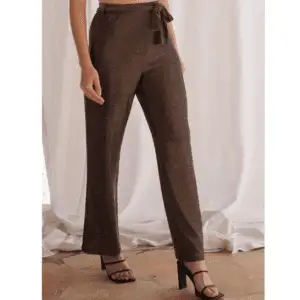 Pantalón de la marca HBT modelo Lennon en color oro. Pantalón largo confeccionado en mezcla de lúrex dorado y poliamida italiana. Lurex dorado en el exterior mientras que el interior está forrado de poliamida un look elegante y cómodo. Corte amplio y cintura alta, resaltando perfectamente tu figura.