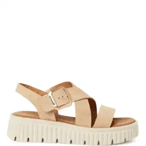 Sandalia de la marca Tamaris modelo 28703-44 en color beig. Sandalia plana con tiras anchas de ante. Cierre con hebilla. Suela de goma con plataforma de 4,5 cm de altura.